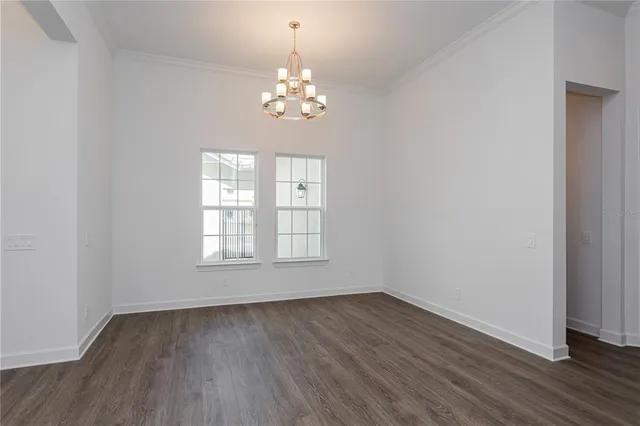 a view of empty room with wooden floor and window