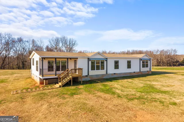 a dining room with furniture a chandelier and wooden floor