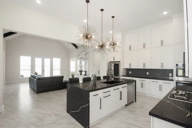 a kitchen with stainless steel appliances kitchen island granite countertop a stove a sink and a refrigerator