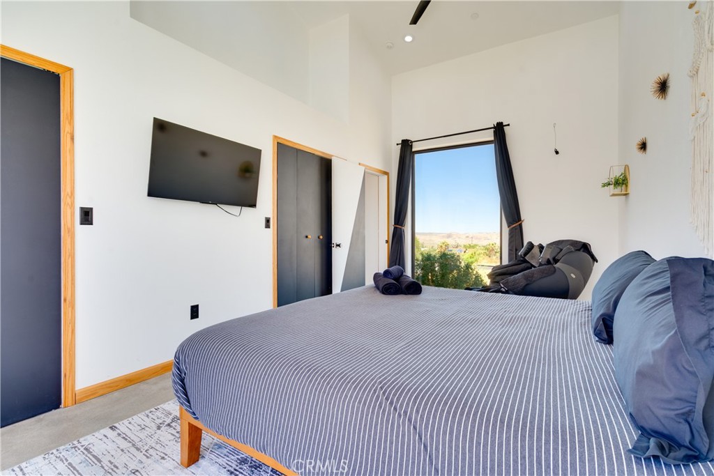60423 La Mirada Trail Joshua Tree, CA 92252 - Photo 13 of 29 a bedroom with a bed and a flat screen tv