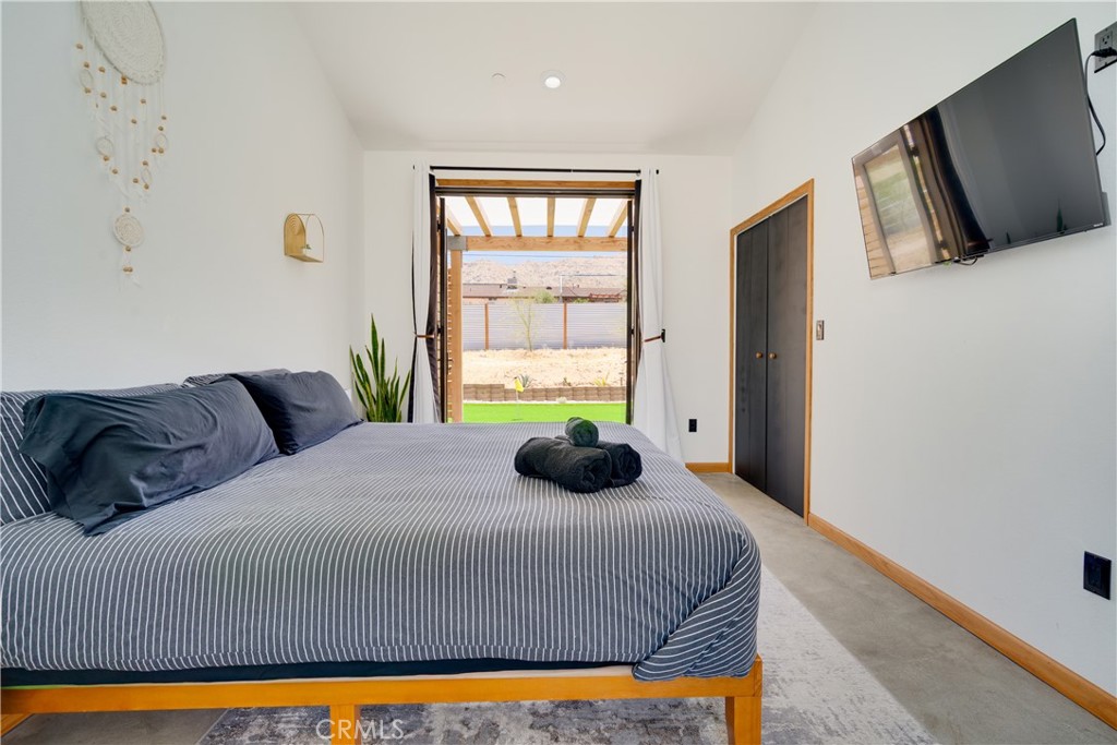 60423 La Mirada Trail Joshua Tree, CA 92252 - Photo 17 of 29 a bed sitting in a bedroom next to a window