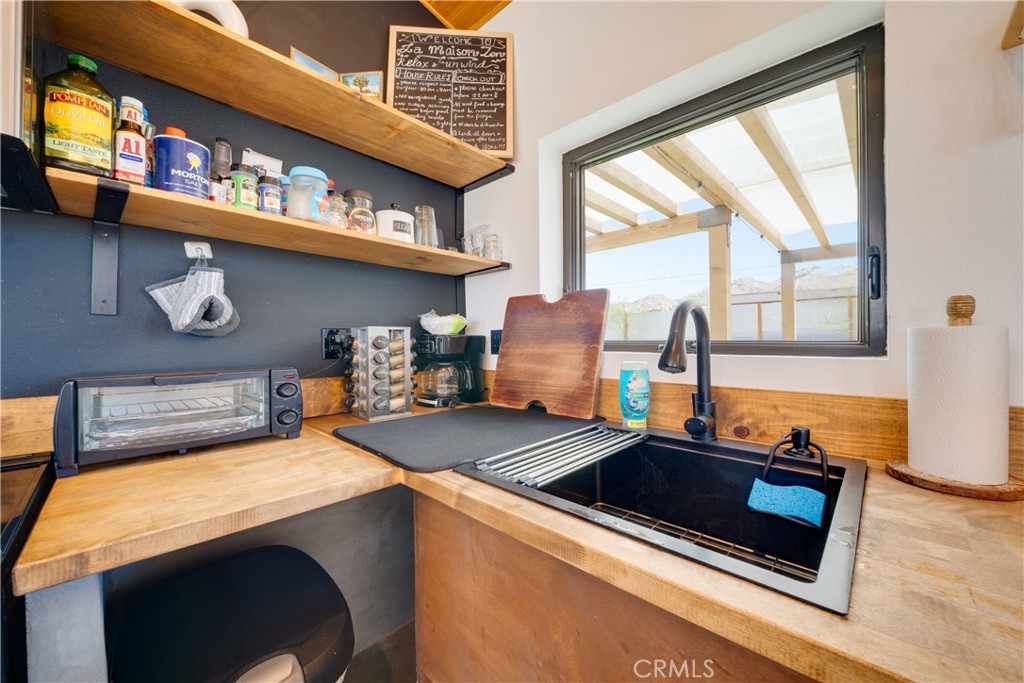 60423 La Mirada Trail Joshua Tree, CA 92252 - Photo 8 of 29 a kitchen with stainless steel appliances granite countertop a stove a sink and a microwave