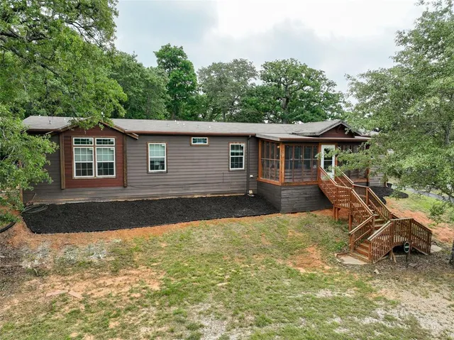 a view of a house with backyard and sitting area