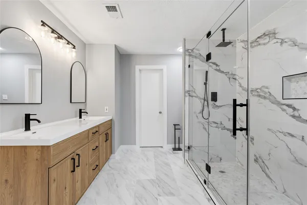 a bathroom with a double vanity sink mirror double and shower