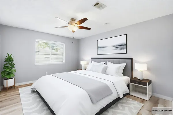 a bedroom with a large bed and a chandelier