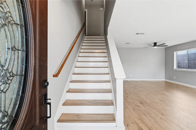 a view of staircase with wooden floor and white walls