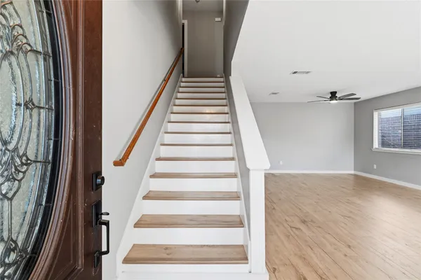 a view of staircase with wooden floor and white walls