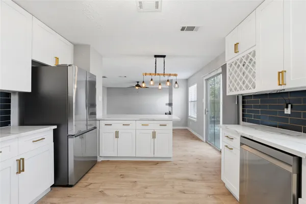a kitchen with white cabinets and stainless steel appliances