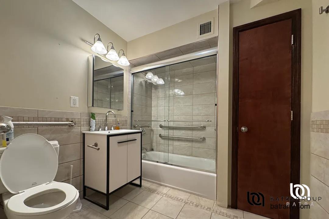 6 East 126th Street, Unit 1 Manhattan, NY 10035 - Photo 11 of 18 a bathroom with a granite countertop sink toilet mirror and bathtub