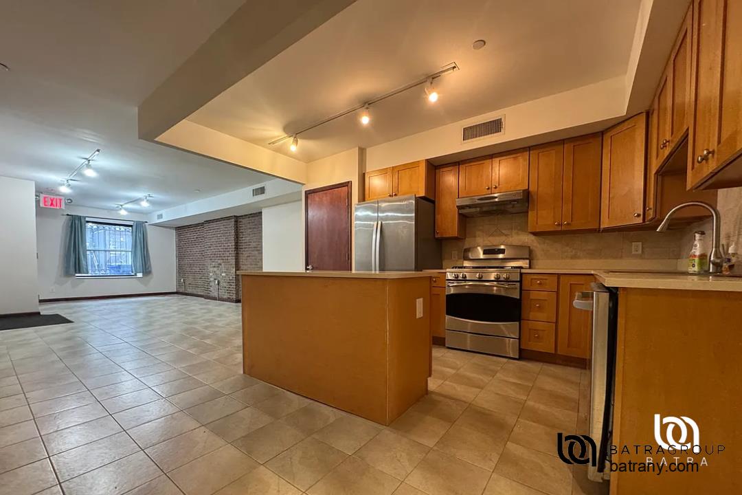 6 East 126th Street, Unit 1 Manhattan, NY 10035 - Photo 2 of 18 a kitchen with stainless steel appliances granite countertop a stove a sink and a refrigerator