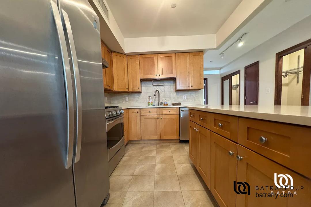 6 East 126th Street, Unit 1 Manhattan, NY 10035 - Photo 8 of 18 a kitchen with granite countertop stainless steel appliances a sink and cabinets