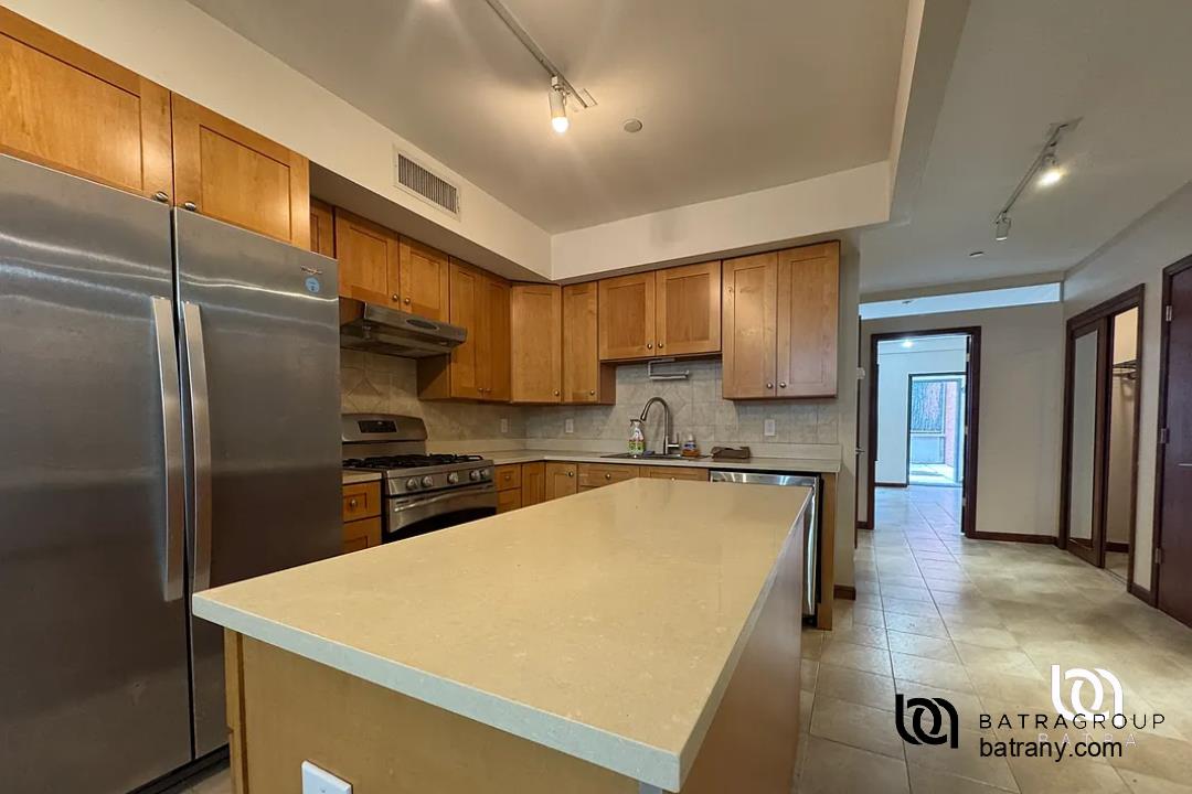 6 East 126th Street, Unit 1 Manhattan, NY 10035 - Photo 9 of 18 a kitchen with stainless steel appliances granite countertop refrigerator sink and cabinets