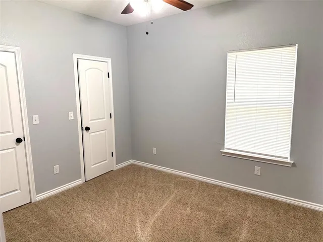 an empty room with windows and closet