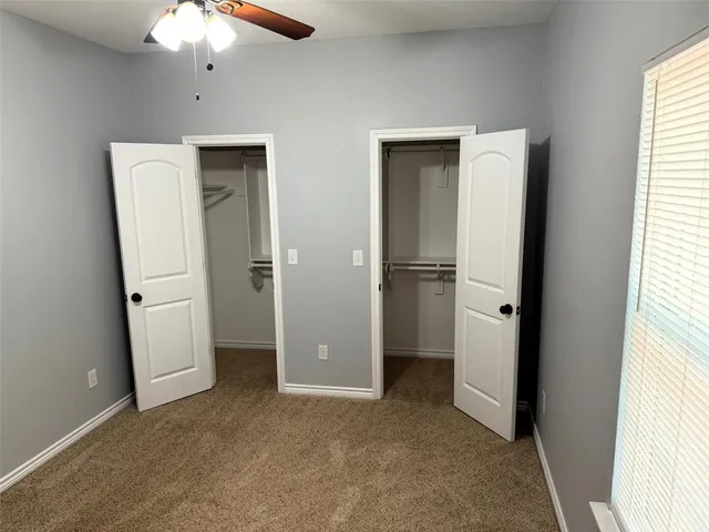 an empty room with closet and a window