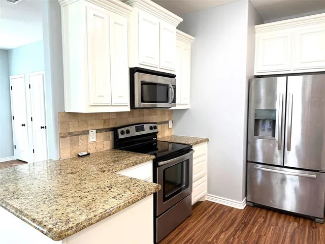 a kitchen with stainless steel appliances granite countertop a refrigerator stove and microwave