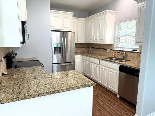 a kitchen with a sink a refrigerator and cabinets