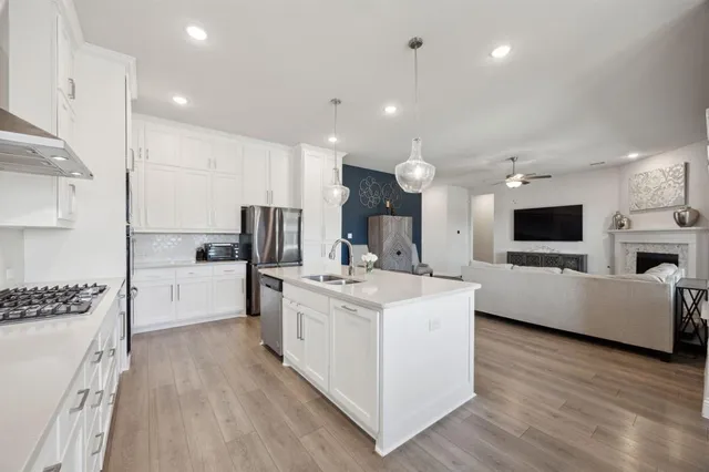 a view of kitchen with stainless steel appliances kitchen island a sink and a stove
