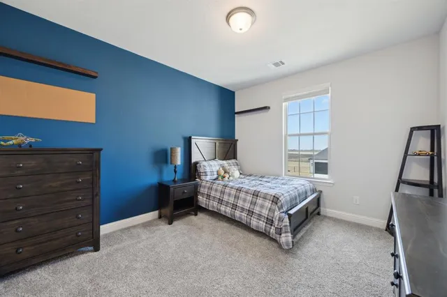 a room with a bed and a tv on the dresser