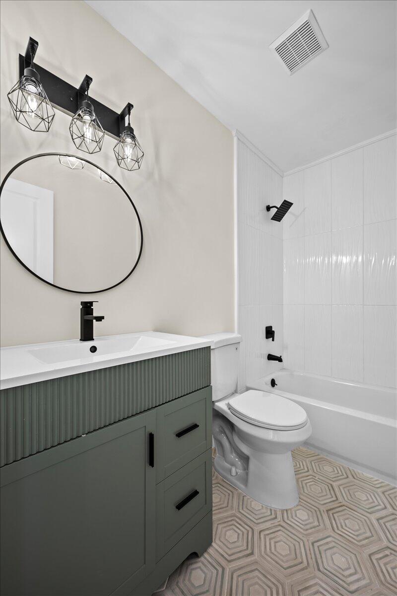 126 Wandering Trail Jupiter, FL 33458 - Photo 11 of 16 a bathroom with a sink a toilet and a mirror