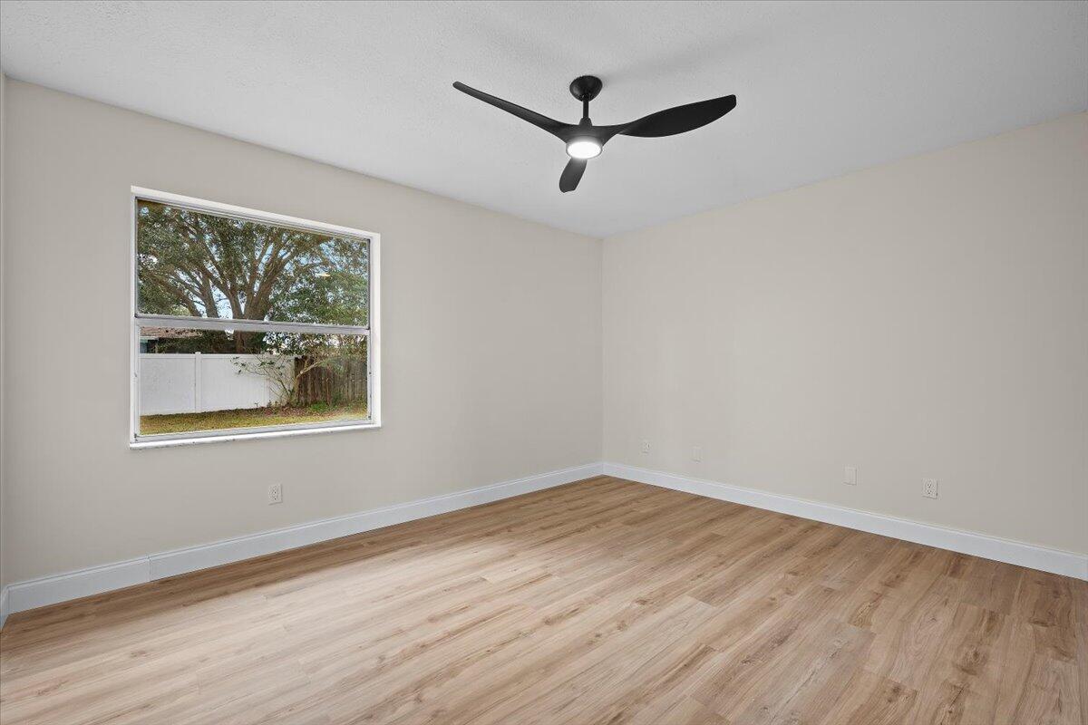 126 Wandering Trail Jupiter, FL 33458 - Photo 12 of 16 a view of a big room with wooden floor and a window