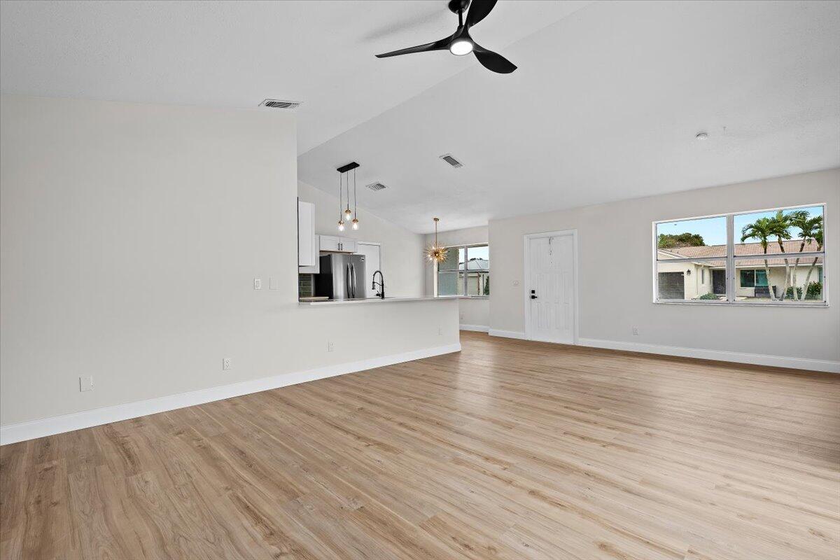 126 Wandering Trail Jupiter, FL 33458 - Photo 3 of 16 a view of a room with wooden floor and windows