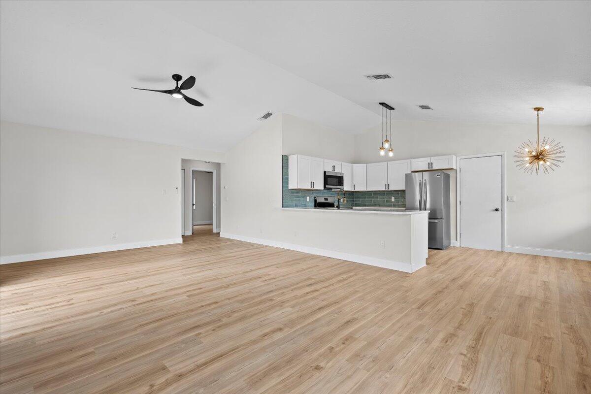 126 Wandering Trail Jupiter, FL 33458 - Photo 4 of 16 a view of a kitchen with a sink and a wooden floor