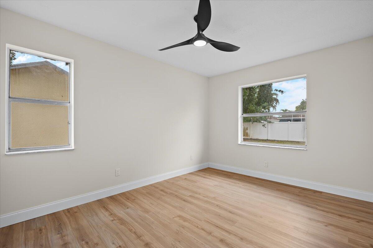 126 Wandering Trail Jupiter, FL 33458 - Photo 9 of 16 a view of empty room with window and wooden floor