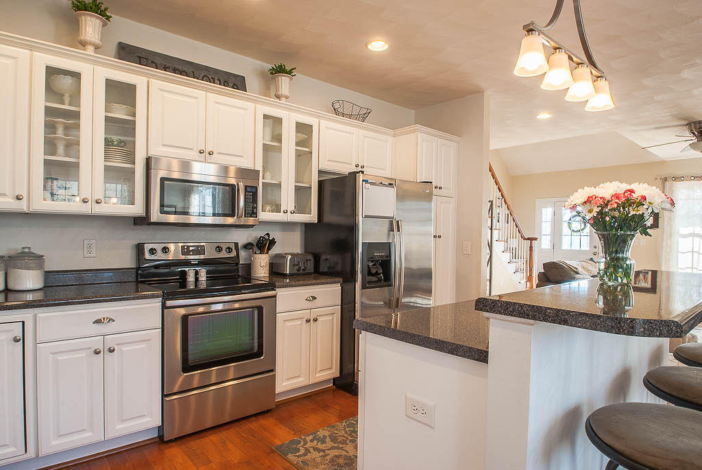 2559 Salt Pond Road Blue Ridge, VA 24064 - Photo 14 of 39 a kitchen with stainless steel appliances granite countertop a refrigerator a stove top oven a sink dishwasher and white cabinets with wooden floor