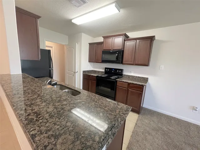 a view of a kitchen with a sink and a chandelier