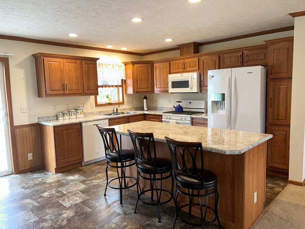 927 Lawsonham Road Rimersburg, PA 16248 - Photo 4 of 33 a kitchen with stainless steel appliances granite countertop a table chairs sink refrigerator and cabinets