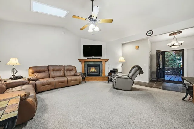 a view of a dining room with furniture a chandelier and window