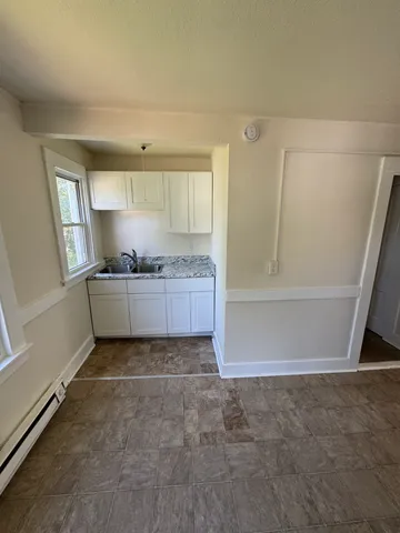 a view of a kitchen with refrigerator and window