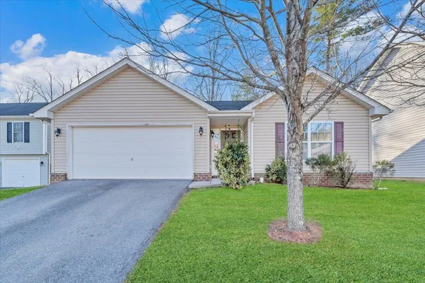 a front view of a house with a yard and trees