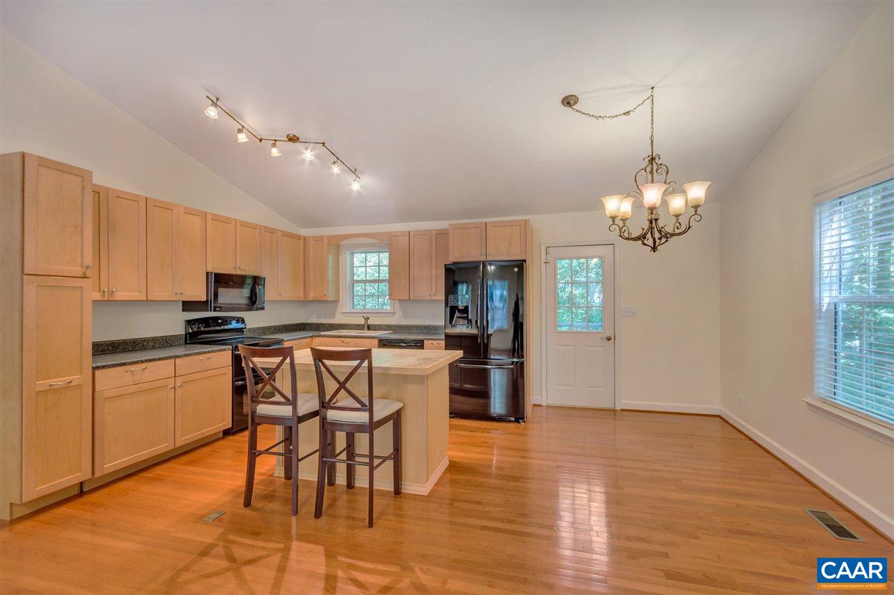 67 Amethyst Road Palmyra, VA 22963 - Photo 6 of 33 a kitchen with stainless steel appliances granite countertop a stove top oven a refrigerator a sink a dining table and chairs with wooden floor