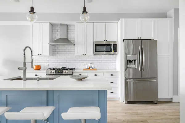 a kitchen with stainless steel appliances a sink a refrigerator a counter space and cabinets