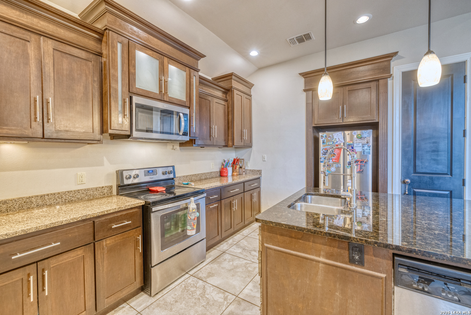 137 Sutton Place Uvalde, TX 78801 - Photo 18 of 31 a kitchen with stainless steel appliances granite countertop a stove a sink and a refrigerator