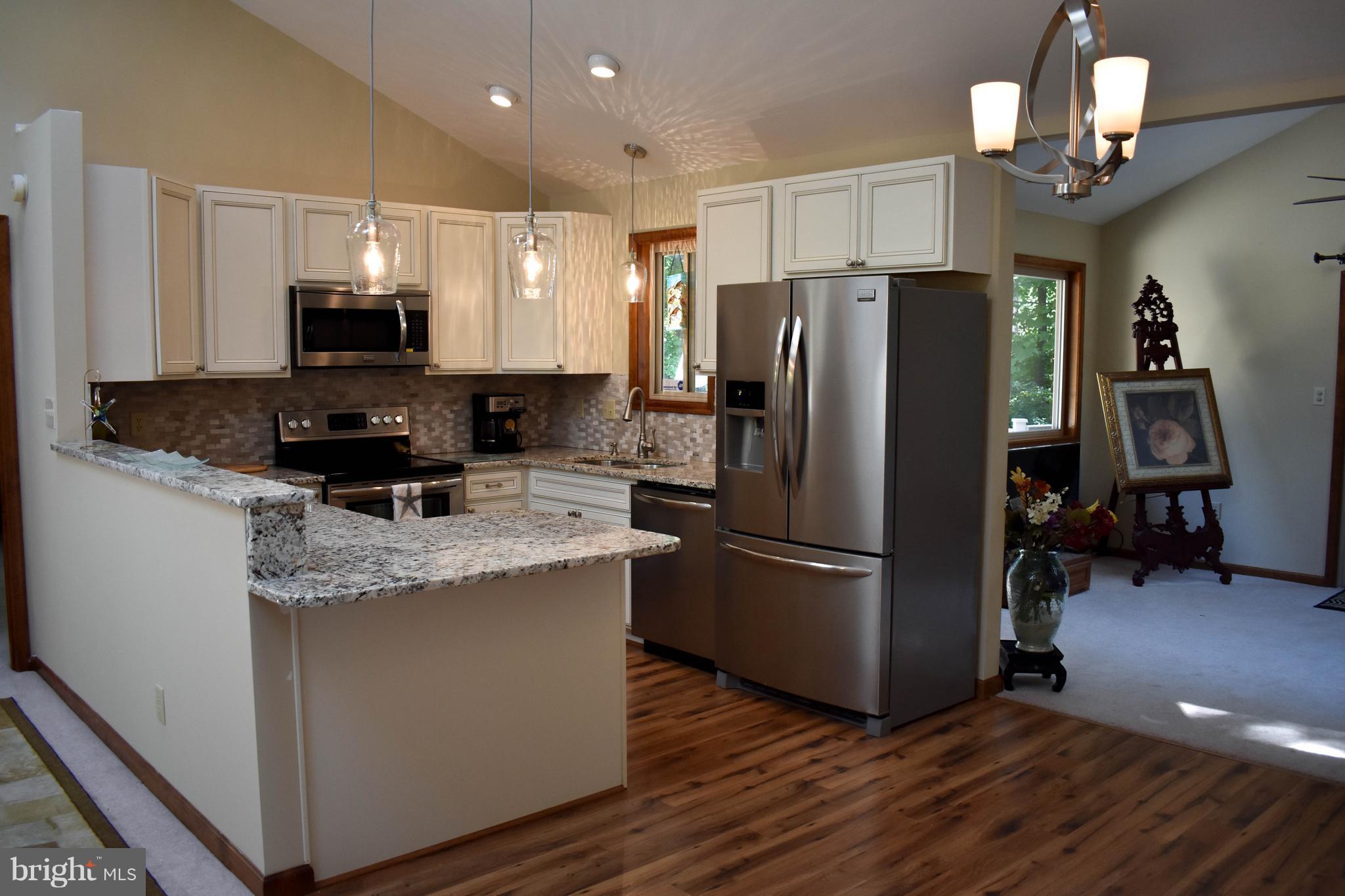 15 Sandyhook Road Ocean Pines, MD 21811 - Photo 8 of 29 a kitchen with stainless steel appliances granite countertop a refrigerator a stove a sink and a microwave
