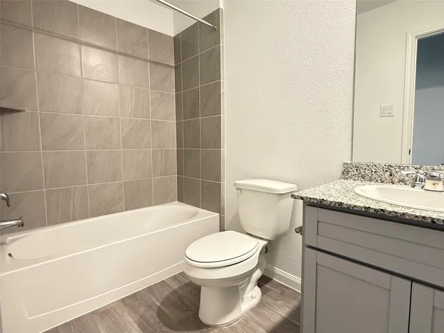 a bathroom with a granite countertop toilet a sink and bathtub