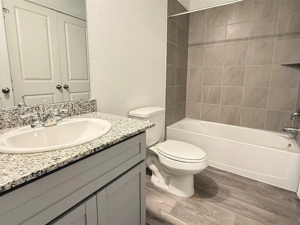 a bathroom with a granite countertop toilet a sink and bathtub