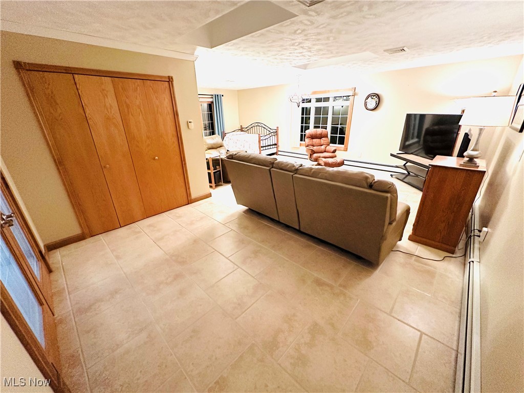 1684 Morris Street Mineral Ridge, OH 44440 - Photo 30 of 50 Living area featuring a textured ceiling, baseboards, and light tile patterned floors