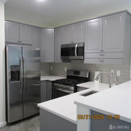 a kitchen with stainless steel appliances a refrigerator a sink a stove a microwave and cabinets