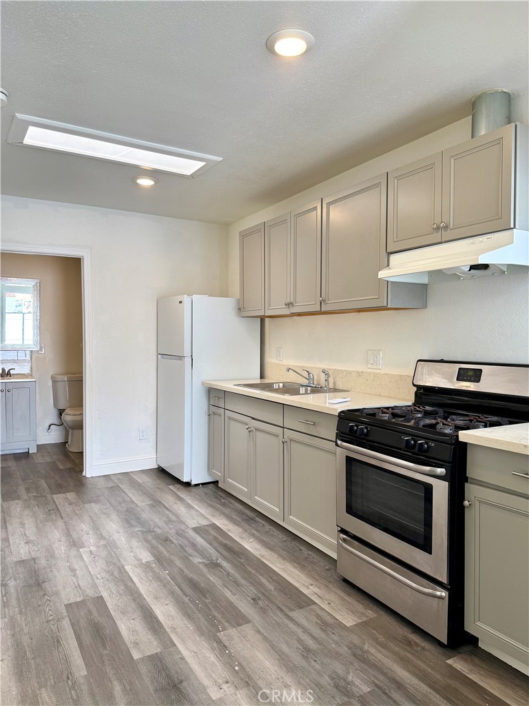6714 Etiwanda Avenue Reseda, CA 91335 - Photo 4 of 7 a kitchen with granite countertop white cabinets and white appliances