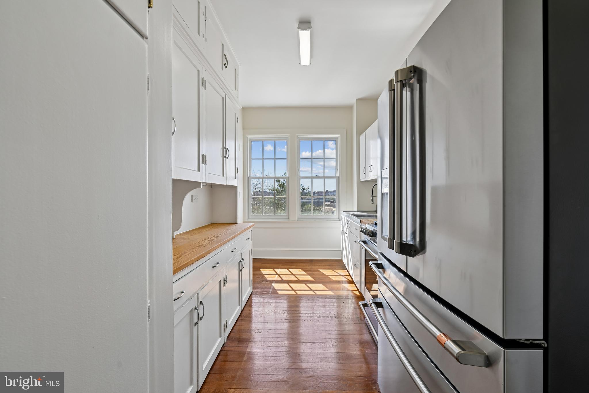 1661 Crescent Place Northwest, Unit 502 Washington, DC 20009 - Photo 25 of 50 a kitchen with granite countertop a refrigerator and a stove