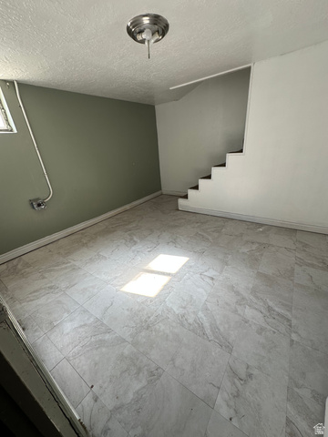 8320 West 3100th Street South Magna, UT 84044 - Photo 21 of 41 Spare room with stairs and a textured ceiling
