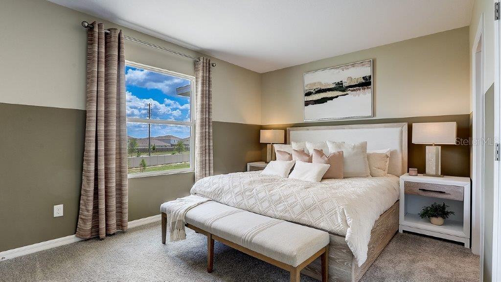 32559 Midsummer Night Lane Wesley Chapel, FL 33543 - Photo 12 of 19 a bedroom with a bed and a painting on the wall