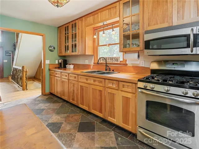 a kitchen with stainless steel appliances a sink stove and cabinets