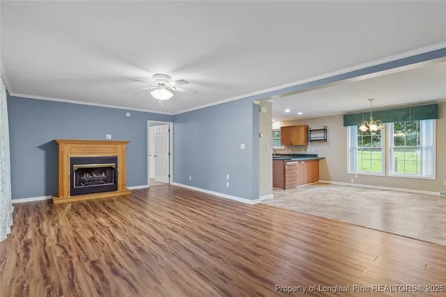 a view of an empty room with a window and a kitchen
