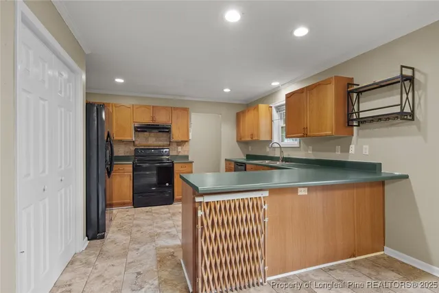 a kitchen with granite countertop wooden cabinets stainless steel appliances and a window