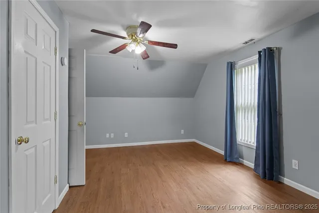a view of an empty room with wooden floor and entryway