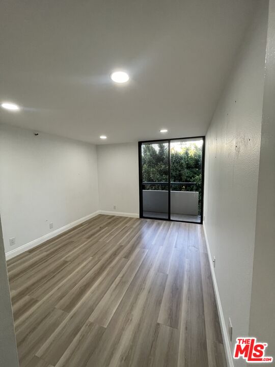 600 West 9th Street, Unit 316 Los Angeles, CA 90015 - Photo 13 of 29 an empty room with wooden floor and windows